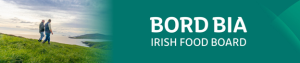 bord bia logo banner, with a photo to the left of two men walking in a filed on a hillside beside the sea.