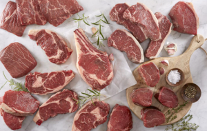Different cuts of red meat on white table