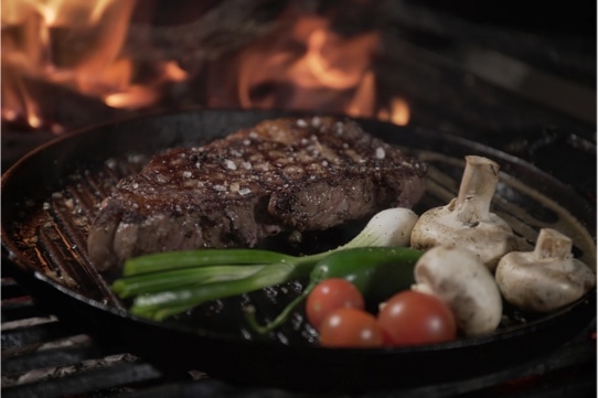 steak on a griddle with vegetables