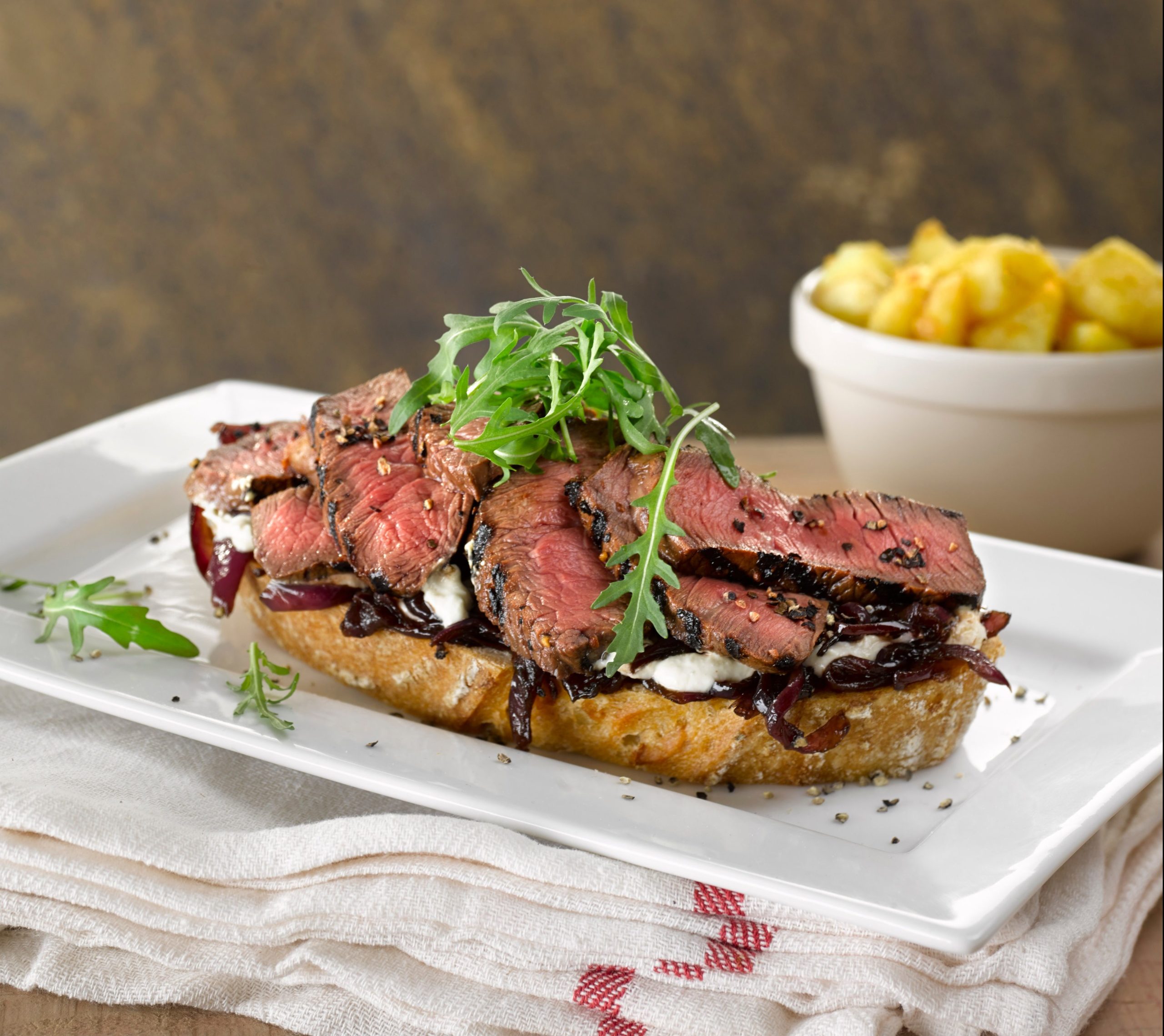 Caramelised red onion with sliced steak on top