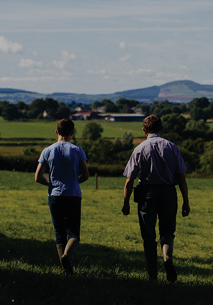 A farmer and his sone walking through a field