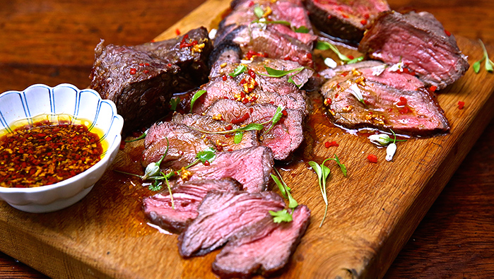 slices rare beef on chopping board