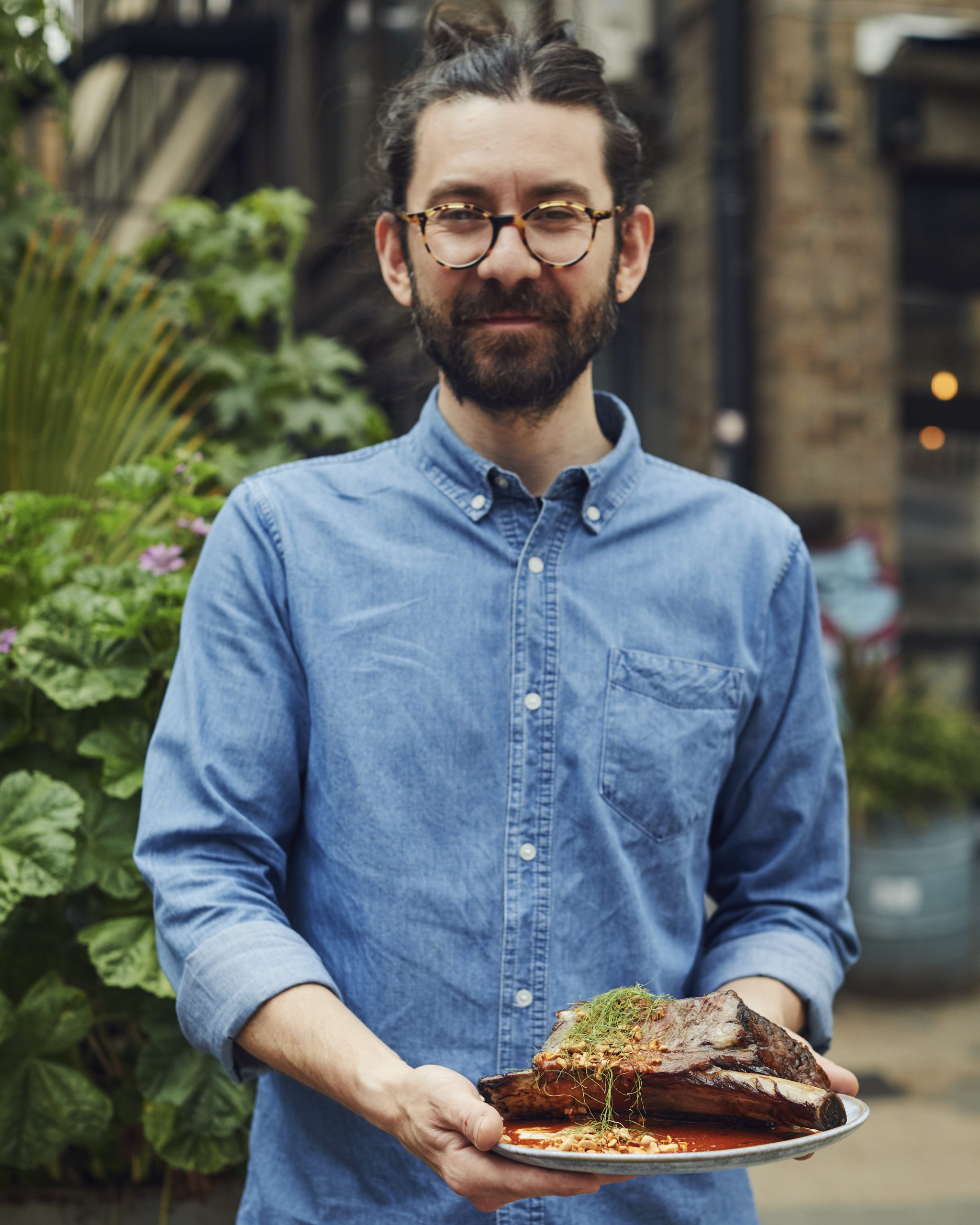 Chef John Chantarasak holding a beef dish